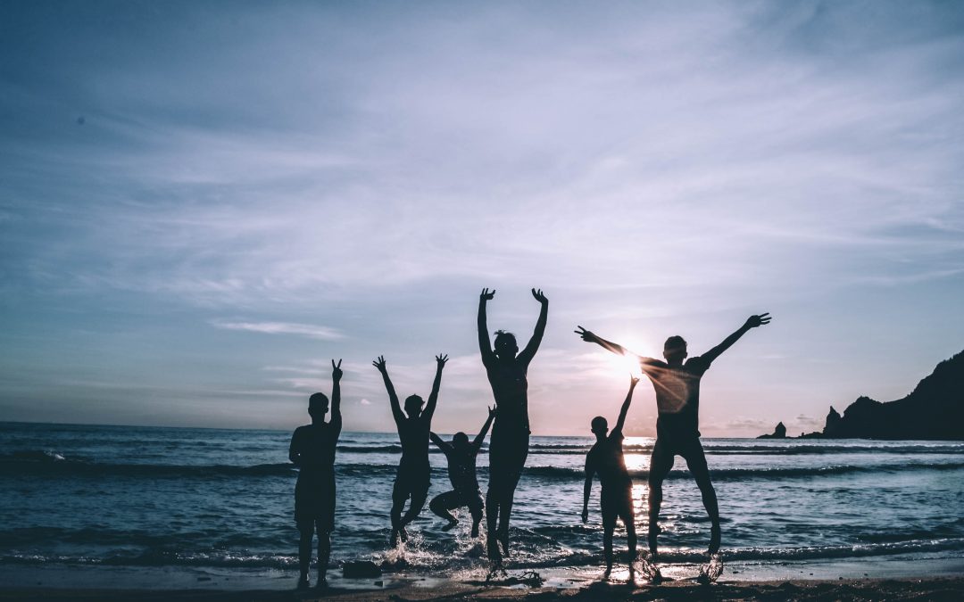 Family playing on beach, jumping in the air, No-one 'trying' to be a good parent.